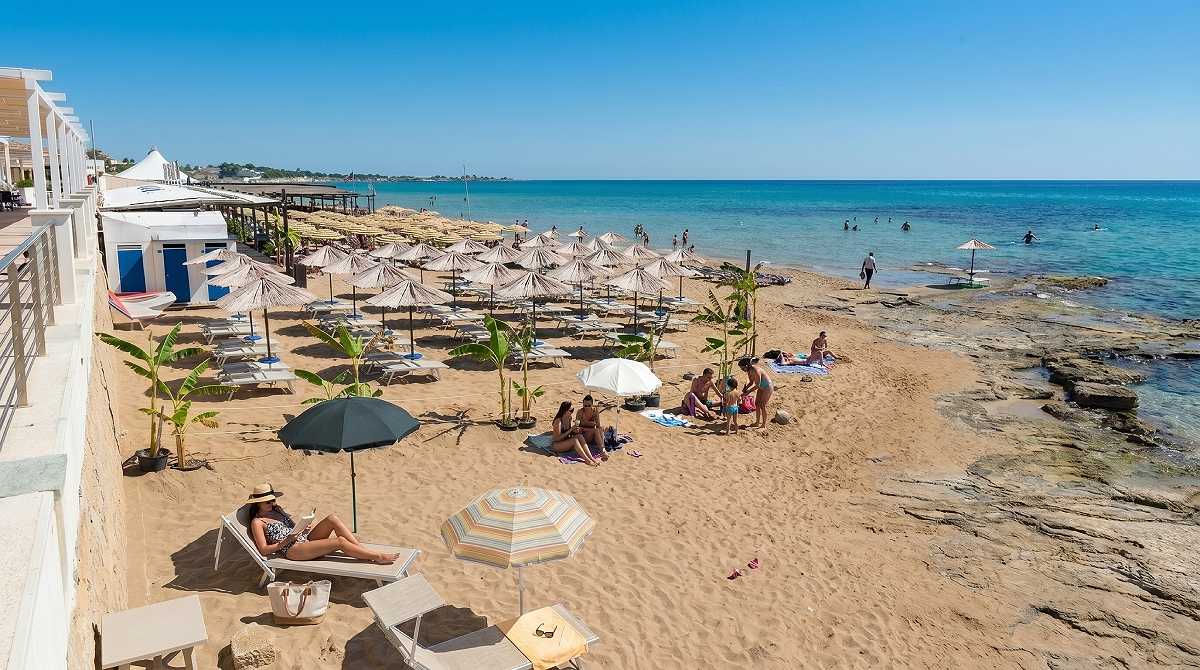 The long sandy seafront of Marina di Noto with lidos and shallow turquoise water